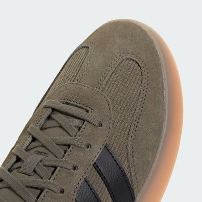 Detail tenisky Adidas se semišovým svrškem a gumovou podrážkou.