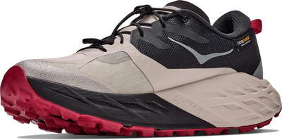 Beige und schwarze Hoka Trailrunning-Schuhe mit roter Sohle und Schnellverschluss. Beige und schwarze Hoka Trailrunning-Schuhe mit roter Sohle und Schnellverschluss.