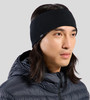 Ein Mann mit langen Haaren trägt ein schwarzes Stirnband und eine Daunenjacke.