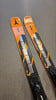 Atomic Redster Skier mit orangefarbenem Design auf grauer Oberfläche.