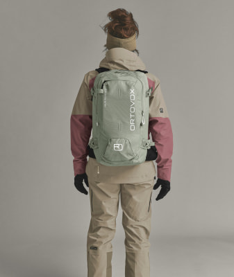Rückansicht einer Person mit einem Ortovox-Rucksack in Bergsteigerkleidung. Rückansicht einer Person mit einem Ortovox-Rucksack in Bergsteigerkleidung.
