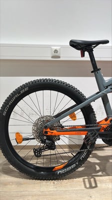 Rückseite eines Mountainbikes mit orangefarbenen Details und schwarzem Reifen. Rückseite eines Mountainbikes mit orangefarbenen Details und schwarzem Reifen.