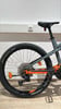 Rückseite eines Mountainbikes mit orangefarbenen Details und schwarzem Reifen.