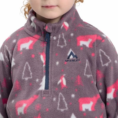 Das Mädchen trägt einen grauen Fleece-Pullover mit einem Aufdruck von Bären und Bäumen. Das Mädchen trägt einen grauen Fleece-Pullover mit einem Aufdruck von Bären und Bäumen.