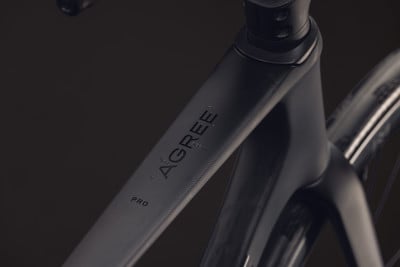 Detail eines schwarzen Fahrradrahmens mit der Aufschrift AGREE PRO. Detail eines schwarzen Fahrradrahmens mit der Aufschrift AGREE PRO.
