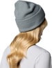 Mädchen mit blondem Haar trägt eine graue Mütze und ein weißes T-Shirt.
