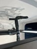 Ein schwarzer Fahrradlenker mit umwickeltem Lenkerband und Schatten von Radfahrern an der Wand.