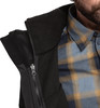 Detail eines Mannes in einer geöffneten schwarzen Jacke und einem karierten Hemd.