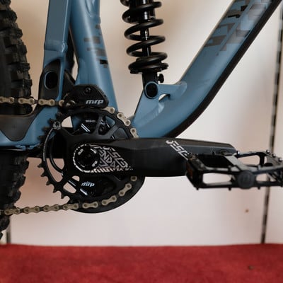 Detailaufnahme von Kurbelgarnitur, Kettenblatt und Dämpfer eines Mountainbikes. Detailaufnahme von Kurbelgarnitur, Kettenblatt und Dämpfer eines Mountainbikes.