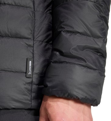 Detail einer schwarzen Jacke mit ClimaWarm-Logo und gestepptem Ärmel. Detail einer schwarzen Jacke mit ClimaWarm-Logo und gestepptem Ärmel.
