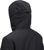 Rückansicht einer Person in einer schwarzen Kapuzenjacke, Detail von Nacken und Schultern.