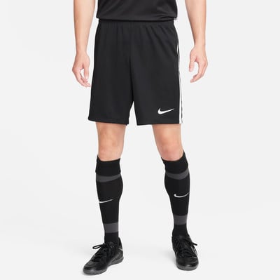 Ein Mann in schwarzen Fußballshorts und Socken mit Nike-Logo. Ein Mann in schwarzen Fußballshorts und Socken mit Nike-Logo.