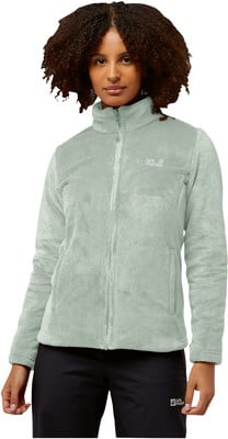 Eine Frau in einer grünen Fleecejacke mit Reißverschluss und schwarzer Hose. Eine Frau in einer grünen Fleecejacke mit Reißverschluss und schwarzer Hose.