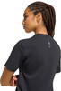 Eine Frau mit Zöpfen im Profil trägt ein schwarzes T-Shirt mit kleinem Aufdruck auf dem Rücken.