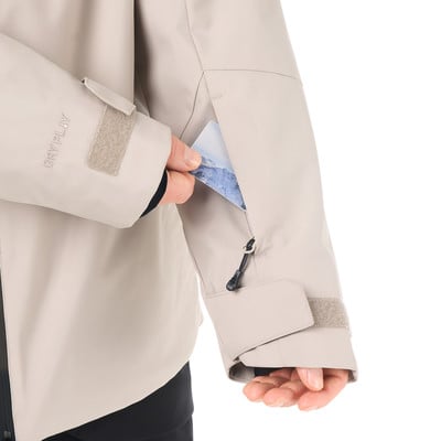 Ein Mann in einer Jacke steckt eine Karte in eine Ärmeltasche. Ein Mann in einer Jacke steckt eine Karte in eine Ärmeltasche.