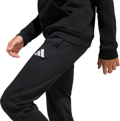 Schwarzer Jogginganzug mit weißem Adidas-Logo am Bein. Schwarzer Jogginganzug mit weißem Adidas-Logo am Bein.