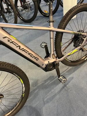 Detail eines grauen Genesis E-Mountainbikes mit gelben Akzenten. Detail eines grauen Genesis E-Mountainbikes mit gelben Akzenten.