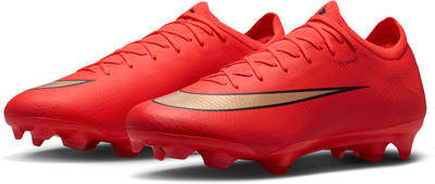 Vorderansicht eines Paares roter Fußballschuhe mit großem goldenem Nike-Logo.