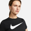 Eine Frau in einem schwarzen T-Shirt mit weißem Nike-Logo auf der Brust.
