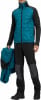 Ein Mann hält eine Jacke, trägt eine gesteppte Jacke und schwarze Hose.