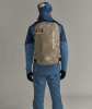 Ein Mann in Skibekleidung mit Rucksack und blauer Mütze.