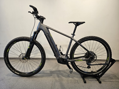 Graues Genesis E-Bike mit schwarzen Rädern und grünen Akzenten auf einem Ständer. Graues Genesis E-Bike mit schwarzen Rädern und grünen Akzenten auf einem Ständer.