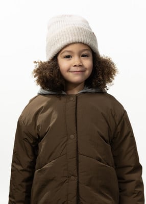 Ein Mädchen mit lockigem Haar und einer Mütze trägt eine braune Jacke.