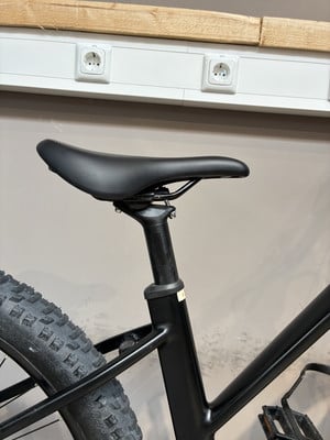 Schwarze Sattelstütze mit schwarzem Sattel an einem Mountainbike. Schwarze Sattelstütze mit schwarzem Sattel an einem Mountainbike.