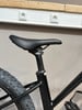 Schwarze Sattelstütze mit schwarzem Sattel an einem Mountainbike.