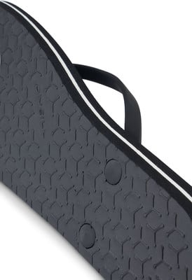 Detail der Sohle eines schwarzen Flip-Flops mit weißem Streifen und O'Neill-Logo. Detail der Sohle eines schwarzen Flip-Flops mit weißem Streifen und O'Neill-Logo.