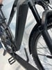 Detail eines E-Bikes mit Akku, Pedal und Vorderradgabel.