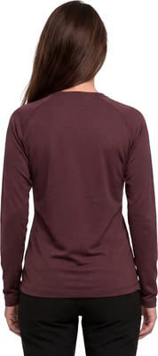 Rückansicht einer Frau mit langen braunen Haaren in einem dunkelweinroten Langarmshirt. Rückansicht einer Frau mit langen braunen Haaren in einem dunkelweinroten Langarmshirt.