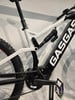 Detail eines Mountain-E-Bikes mit weißem Rahmen und schwarzem Dämpfer.