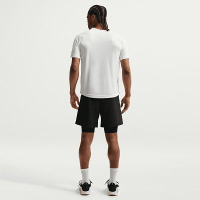 Ein Mann in einem weißen T-Shirt und schwarzen Shorts mit weißen Socken und Schuhen. Ein Mann in einem weißen T-Shirt und schwarzen Shorts mit weißen Socken und Schuhen.