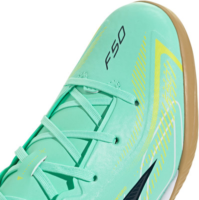 Grüner Fußballschuh mit schwarzem F50-Schriftzug und gelben Streifen. Grüner Fußballschuh mit schwarzem F50-Schriftzug und gelben Streifen.
