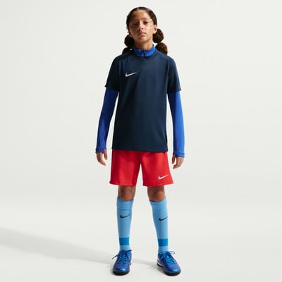 Mädchen in dunkelblauem Shirt, roter Hose und blauen Socken. Mädchen in dunkelblauem Shirt, roter Hose und blauen Socken.