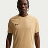 Ein Mann in einem braunen T-Shirt mit Nike-Logo auf der Brust.