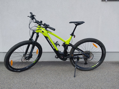 Ein gelbes Mountainbike mit schwarzen Details und Federung wird gezeigt.
