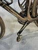 Nahaufnahme eines schwarzen Rennrads mit Fokus auf Kurbel und Pedal.