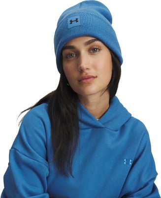 Eine Frau trägt eine blaue Mütze und einen Hoodie mit Under Armour-Logo. Eine Frau trägt eine blaue Mütze und einen Hoodie mit Under Armour-Logo.