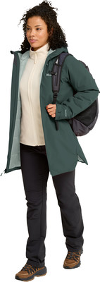 Frau in grüner Jacke und schwarzer Hose mit Rucksack. Frau in grüner Jacke und schwarzer Hose mit Rucksack.
