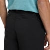 Detail der Gesäßtasche einer schwarzen Hose mit Reißverschluss und blauem Oberteil.