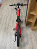 Ein rotes E-Bike mit schwarzem Sattel und Display am Lenker.
