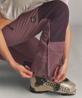 Detail der Hose mit Logo, Reißverschlüssen und Druckknöpfen zur Breitenregulierung. Detail der Hose mit Logo, Reißverschlüssen und Druckknöpfen zur Breitenregulierung.