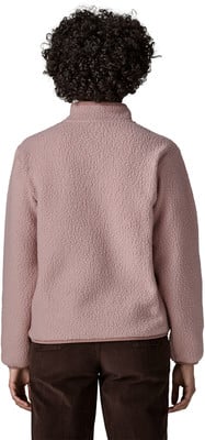 Rückansicht einer Person in einer rosa Fleecejacke und braunen Cordhosen. Rückansicht einer Person in einer rosa Fleecejacke und braunen Cordhosen.