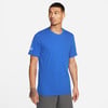 Ein Mann in einem blauen Nike-T-Shirt und grauer Jogginghose steht vor einem weißen Hintergrund.