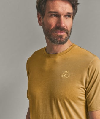 Ein Mann in einem gelben T-Shirt mit einem aufgestickten Symbol einer Mütze und Brille. Ein Mann in einem gelben T-Shirt mit einem aufgestickten Symbol einer Mütze und Brille.