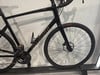 Ein schwarzes Specialized Rennrad mit Scheibenbremsen auf einem Ständer.