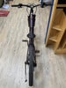 Draufsicht auf ein E-Bike mit violettem Rahmen und orangefarbenen Akzenten.