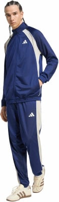 Ein Mann in einem blauen Adidas Trainingsanzug mit beigen Streifen und Logo. Ein Mann in einem blauen Adidas Trainingsanzug mit beigen Streifen und Logo.